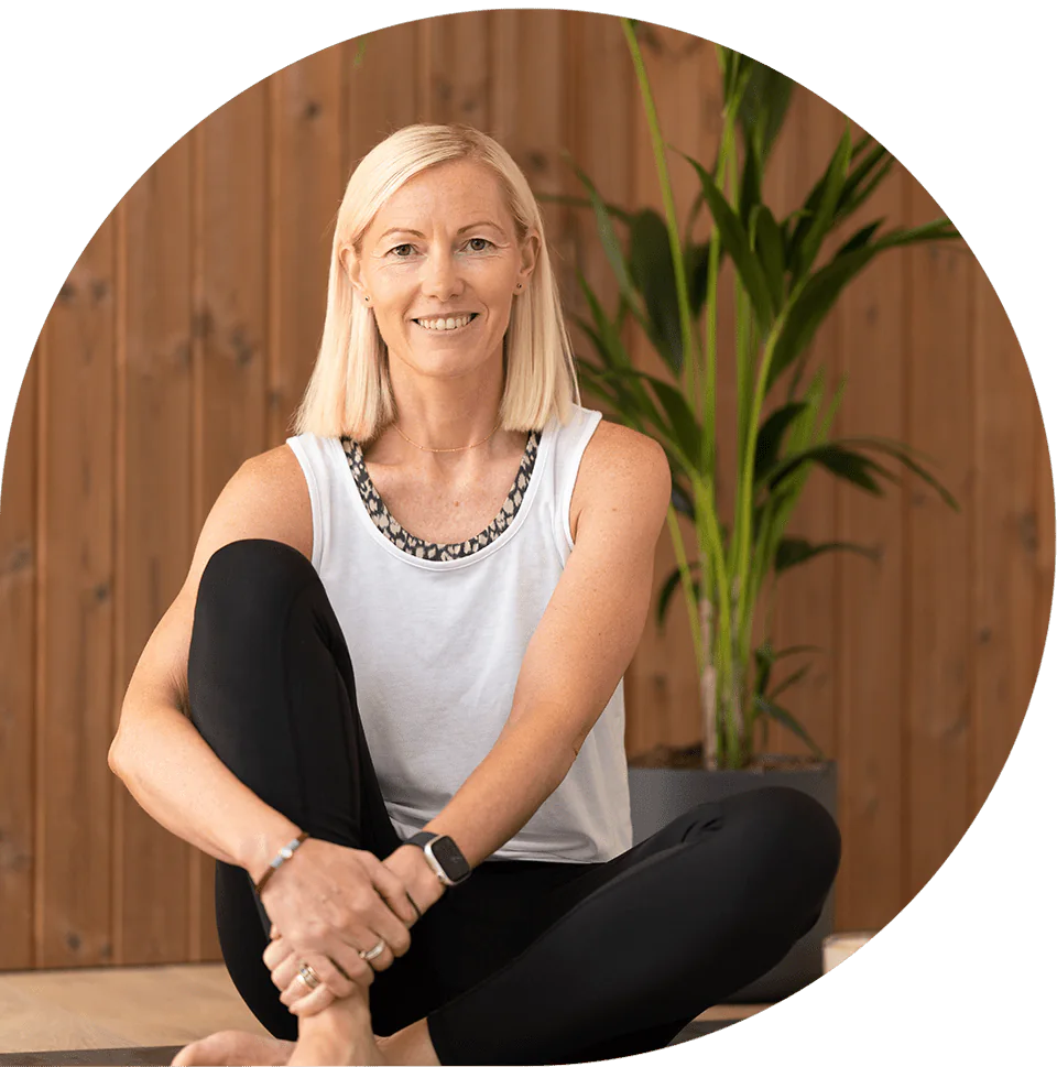 Lisa sitting cross-legged on the studio floor, smiling
