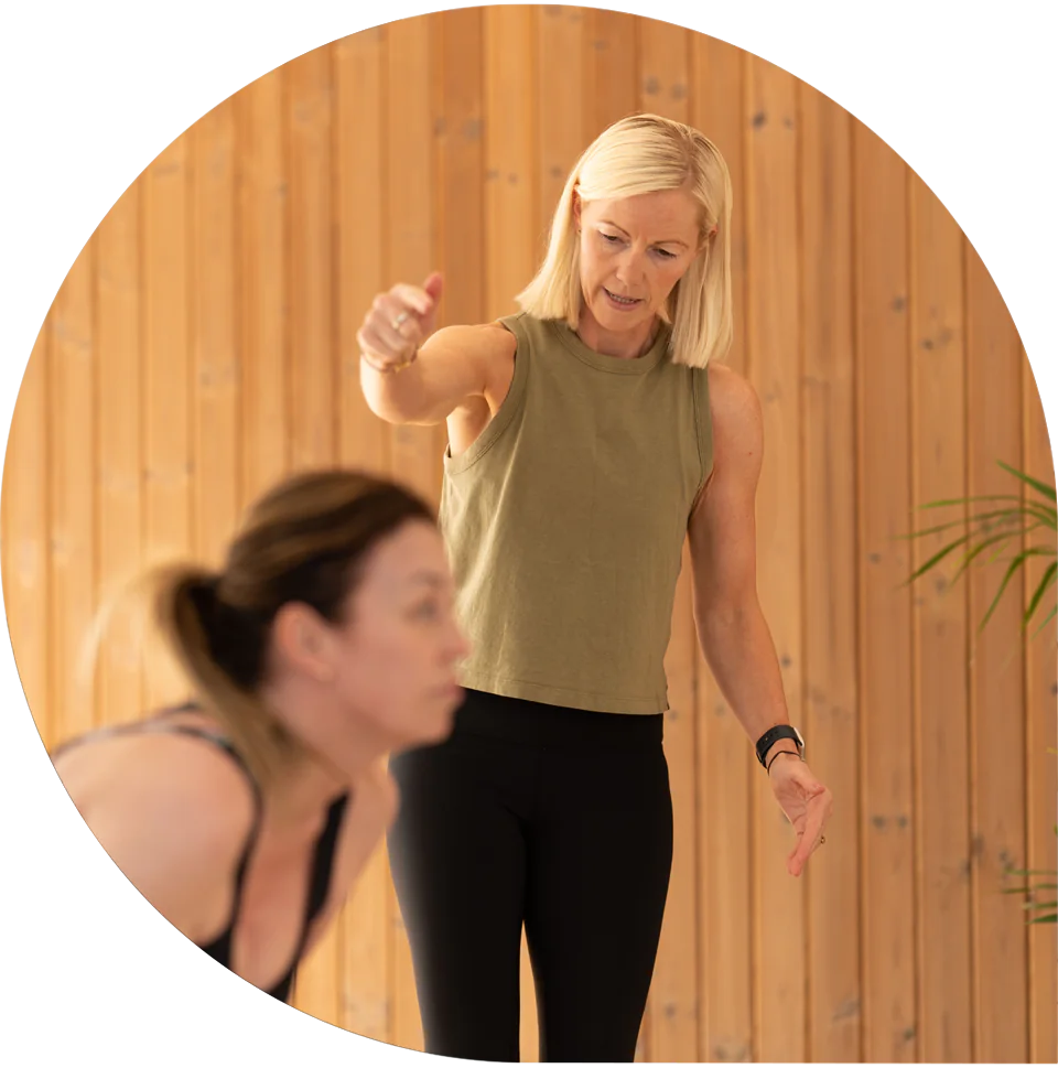 Lisa demonstrating a movement to a client during a session