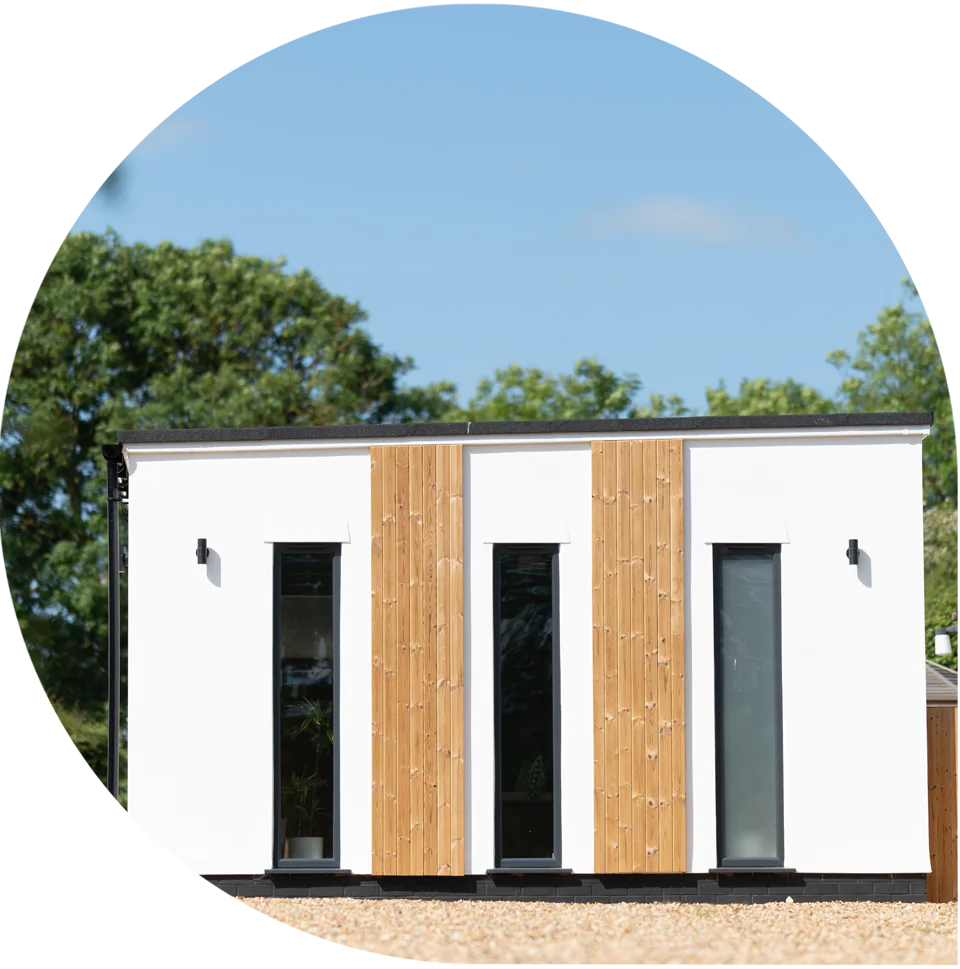 Designed Pilates studio building with trees behind, under a blue sky