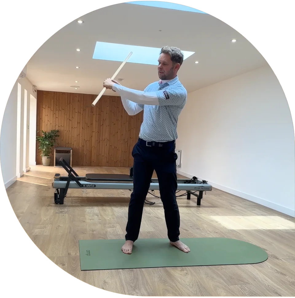 Pro golfer Adam Pike demonstrating a rotation drill with an alignment stick